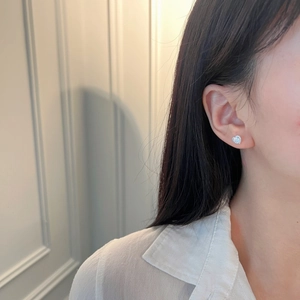 Elegant S925 sterling silver heart stud earrings with sparkling pavé zircons worn by model