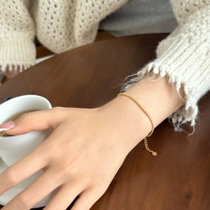 Detailed shot of a gold tennis bracelet with tiny zircons and heart pendant on a wrist