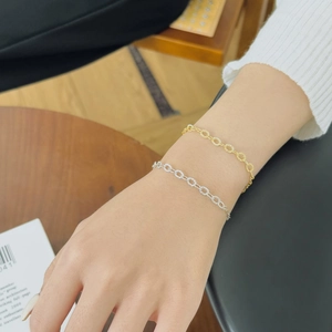 Detailed close-up of dual-tone S925 silver link chain bracelets on female wrist