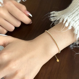 Detail of S925 sterling silver gold tennis bracelet with adjustable heart charm and zircon