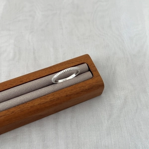 Anello in argento sterling S925 con moissanite pavé in un vassoio di legno