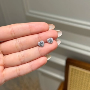 Close-up of S925 sterling silver heart stud earrings with sparkling zircon stones