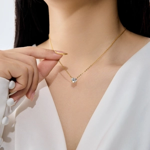 Gros plan du pendentif cœur en cristal doré sur une fine chaîne élégante
