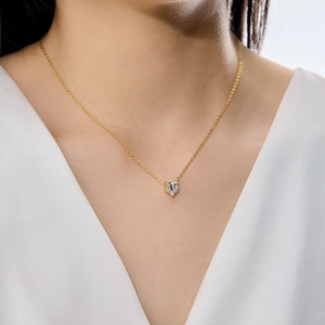 Détail d'un pendentif cœur en zircon sur une délicate chaîne de clavicule en argent doré