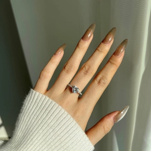 Detail of S925 sterling silver heart-shaped ring with pavé stones on woman's finger