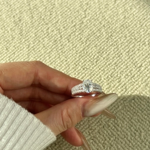 On-hand display of 2 carat oval-cut moissanite sterling silver ring on fabric