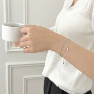 Detail view of S925 sterling silver layered chain bracelet with a square zircon pendant