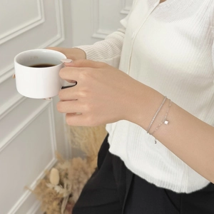 Close-up of a double-layered S925 silver bracelet featuring a square crystal pendant