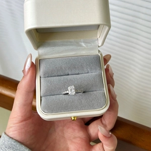 Détail d'une bague en argent S925 avec pierre taille émeraude dans un écrin en cuir blanc