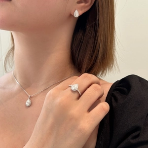 Detailed view of teardrop Moissanite jewelry set on model with necklace and earrings