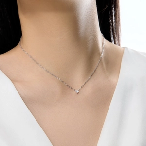 Détail d'un collier en argent 925 avec pendentif cœur en zircon sur un cou de femme
