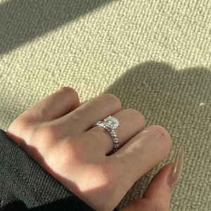Close-up of 2-carat round moissanite ring with twisted S925 silver band on finger