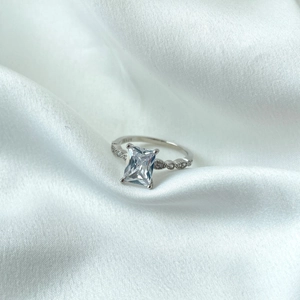 Détail d'une bague en argent S925 avec zircon carré et anneau ondulé serti de diamants