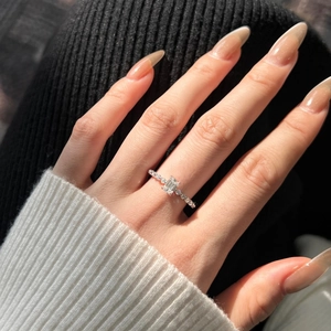 Close-up of S925 sterling silver ring with emerald-cut stone on a hand