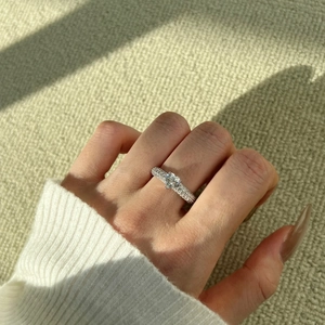 S925 sterling silver heart-shaped moissanite ring with pavé setting on a finger