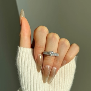 Detailed macro of S925 silver heart ring with double-row pavé diamonds worn on hand