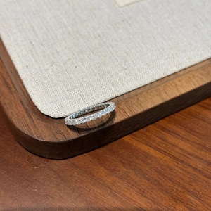 Eternity ring in S925 silver with full moissanite stones on a wooden display tray