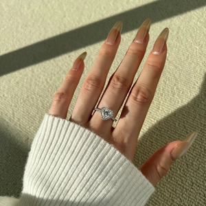 Gros plan d'une bague en argent S925 avec moissanite de cœur portée à la main