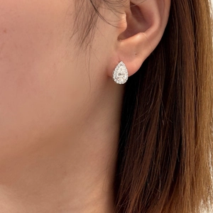 Close-up of S925 silver pear-shaped halo stud earring worn on a model ear
