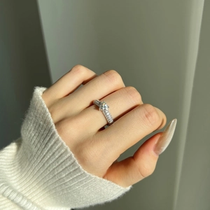 Close-up of sparkling moissanite ring with pavé diamonds on a model's hand