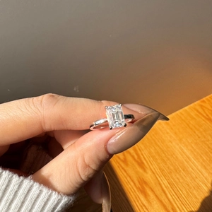 Macro shot of S925 silver ring featuring emerald cut moissanite in classic 4-prong setting