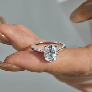 Elegant 3ct oval-cut moissanite S925 sterling silver ring on model's hand with four-prong setting