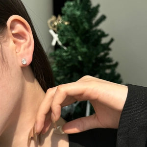Gros plan d'une boucle d'oreille en moissanite ovale en argent S925 portée à l'oreille