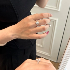 Close-up of pear-shaped moissanite ring with halo setting on a finger