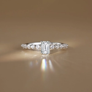Emerald cut moissanite silver ring with side diamonds and rainbow light reflection