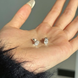 Boucles d'oreilles en argent S925 et moissanite ovale 0,8ct présentées dans la paume de main