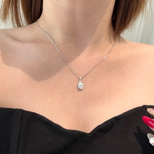 Close-up of a pear-cut moissanite necklace in sterling silver on a female model neck