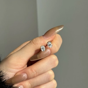 Vue macro de boucles d'oreilles en moissanite ovale en argent S925 avec serti à quatre griffes
