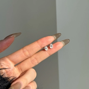Détail de boucles d'oreilles moissanite ovales avec monture argent à quatre griffes