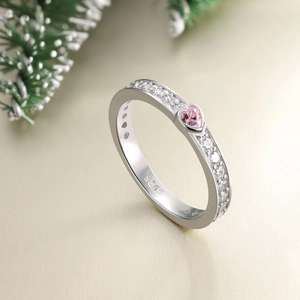 Détail de la bague en argent S925 avec pierre de cœur rose et diamants sur sapin vert
