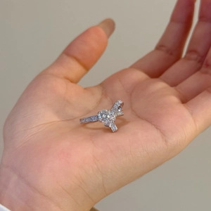 Détail d'une bague nœud en argent sertie de moissanite présentée dans la main