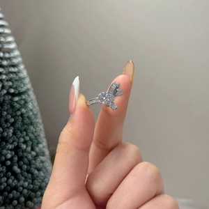 Détail macro d'une bague nœud en argent sertie de diamants étincelants au doigt