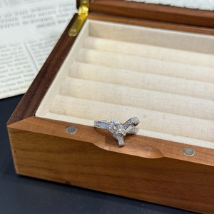 Détail d'une bague nœud en argent S925 avec moissanite brillante sur boîte en bois