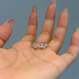 Macro shot of silver butterfly ring with marquise cut stones held on hand palm