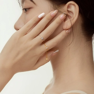Detail of S925 sterling silver chain ring with zircon stone and round gold pendant