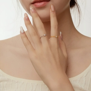 Close-up of minimalist S925 silver chain rings with round zircon on a model hand