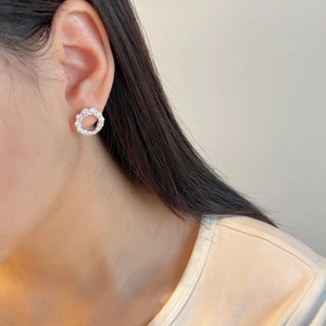 Macro side view of a S925 sterling silver hollow wreath stud earring on a model ear