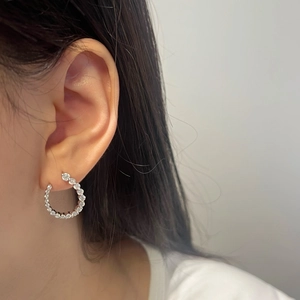 Close-up of S925 sterling silver U-shape earrings with pavé moissanite on model ear