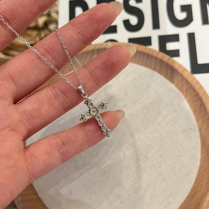 Close-up of S925 silver cross pendant with sparkling stones and vintage engravings