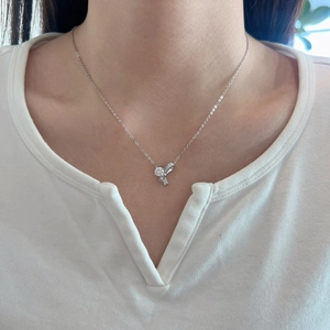 Gros plan d'un collier pendentif nœud en argent S925 avec moissanite sur le cou