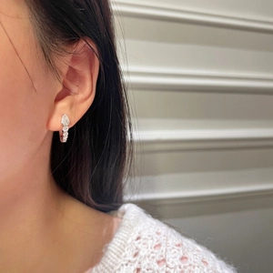 Gros plan de boucles d'oreilles goutte en argent S925 portées avec un pull en maille