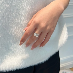 Detail eines S925 Silberrings mit Herz- und Smaragdschliffsteinen am Finger getragen