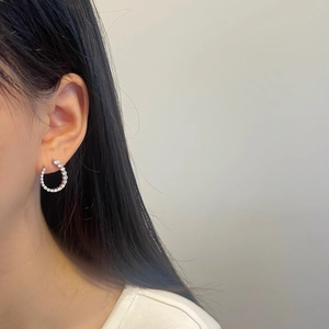Close-up of S925 sterling silver U-shaped earrings with moissanite pavé on female model