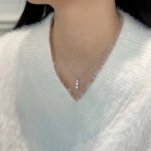 Close-up of three graduated brilliant-cut stones on a silver S925 necklace worn by model