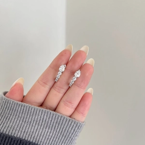 Détail de boucles d'oreilles en moissanite taille poire avec design goutte en argent S925