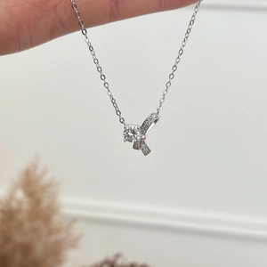 Gros plan du collier en argent S925 avec pendentif ruban et diamant Moissanite brillant